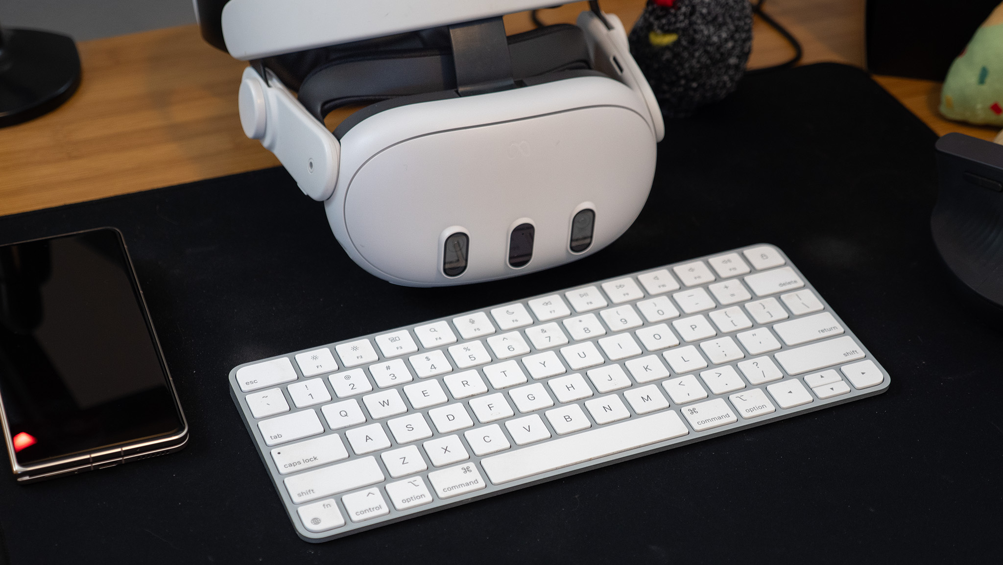 A Meta Quest 3 headset with an Apple keyboard alongside an Honor Magic V5 phone