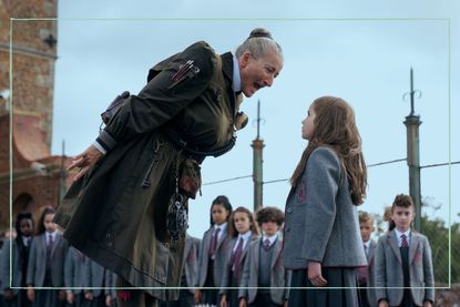 a still from Matilda the Musical showing Emma Thompson shouting at Alisha Weir in a school playground