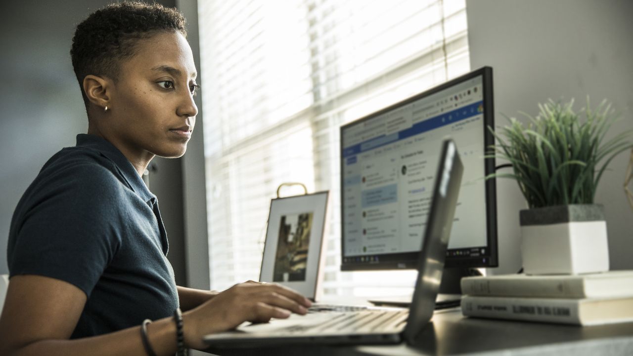 Woman using laptop and PC on Windows