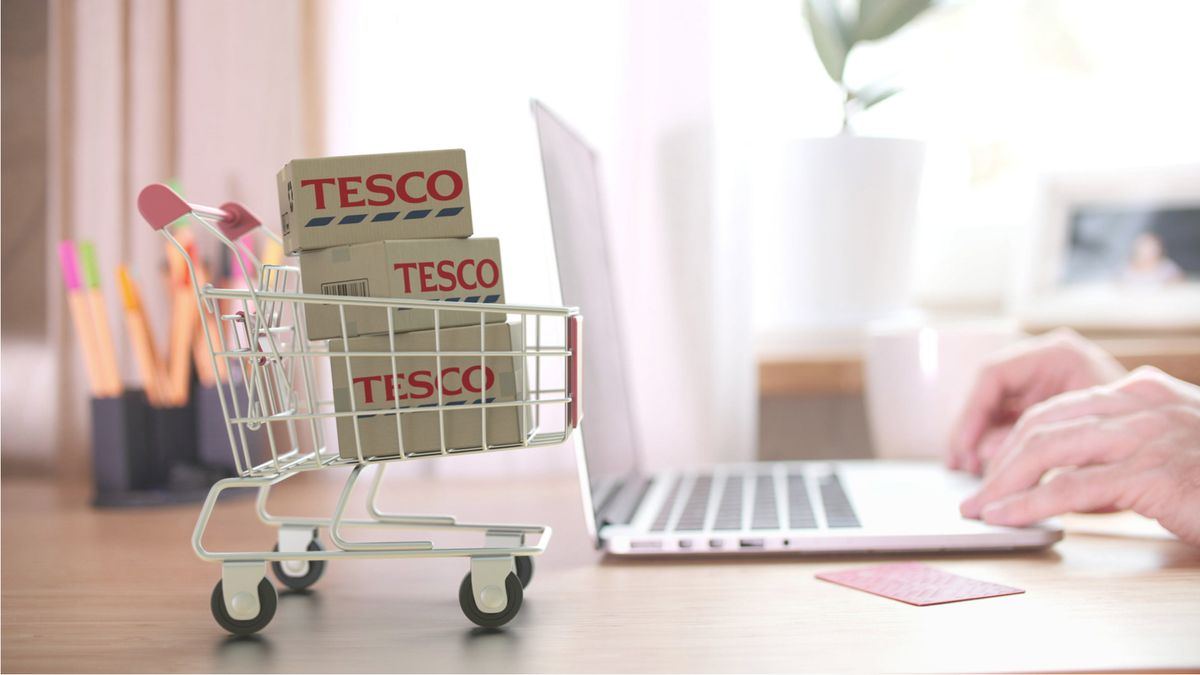 TESCO logo on boxes in shopping cart near the laptop. 