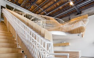 Stairs twists to form the seating surfaces on the edge of the mezzanine