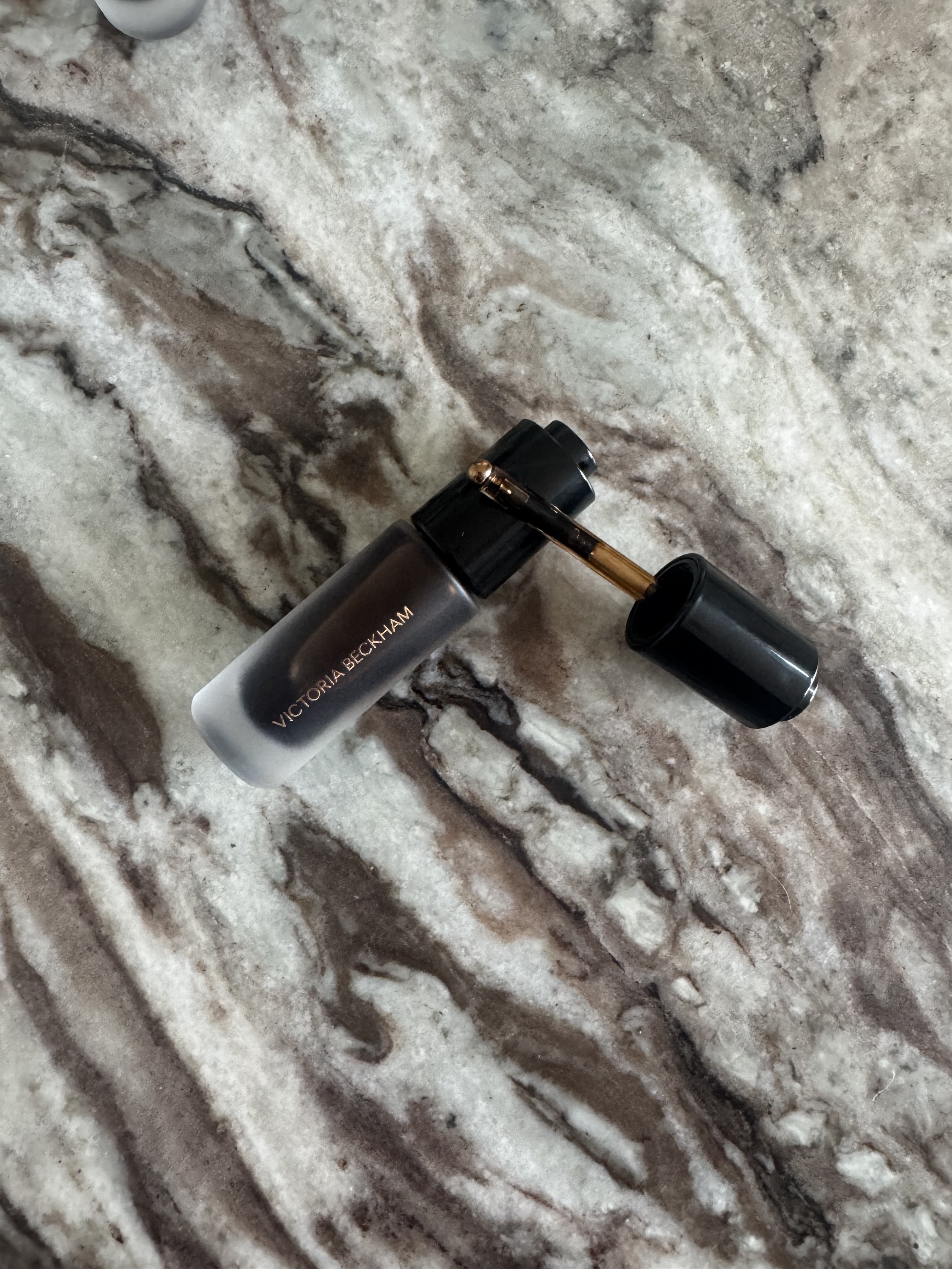 A close up of the Victoria Beckham Beauty Colour Wash Bronze Tint applicator, featuring a pipette with a roller-ball on the end