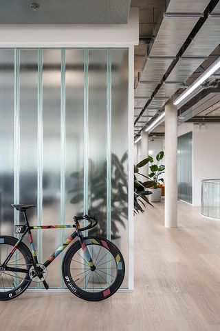 bike against translucent wall at Schwalbe Hybrid Building by Archiproba