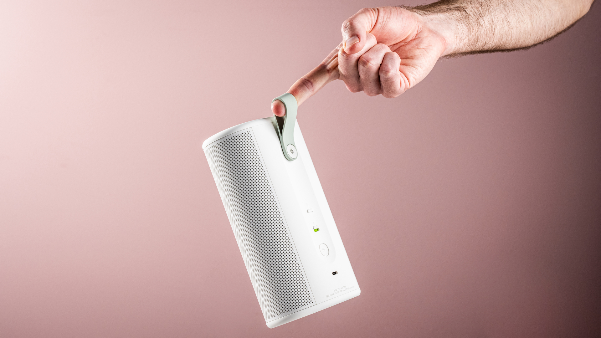 The Sonos Play speaker being held by the carrying hook by a man's hand