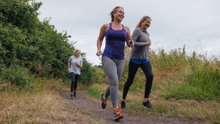 Woman running together along trail path in local area