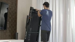 Man folding Echelon Stride treadmill for storage