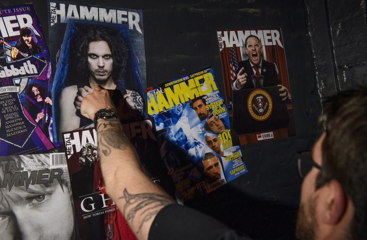 Someone pointing at a Metal Hammer cover on the wall
