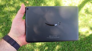 Amazon Fire HD 8 (2020) held in one hand outdoors with grass in the background