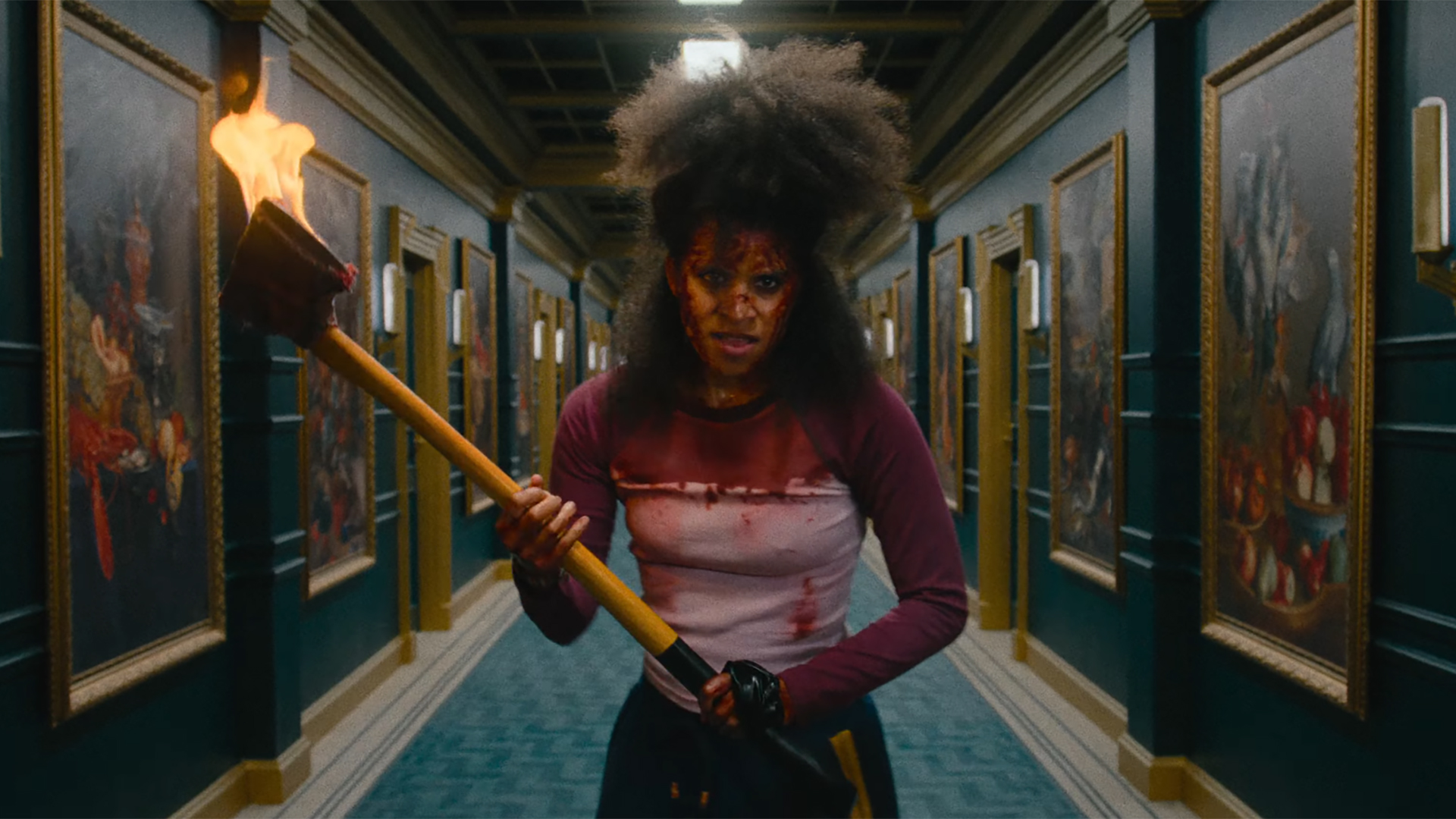 Zazie Beetz in They Will Kill You, covered in blood and wielding a flaming axe
