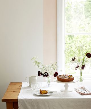 wooden dining table and white walls with a peach painted stripe