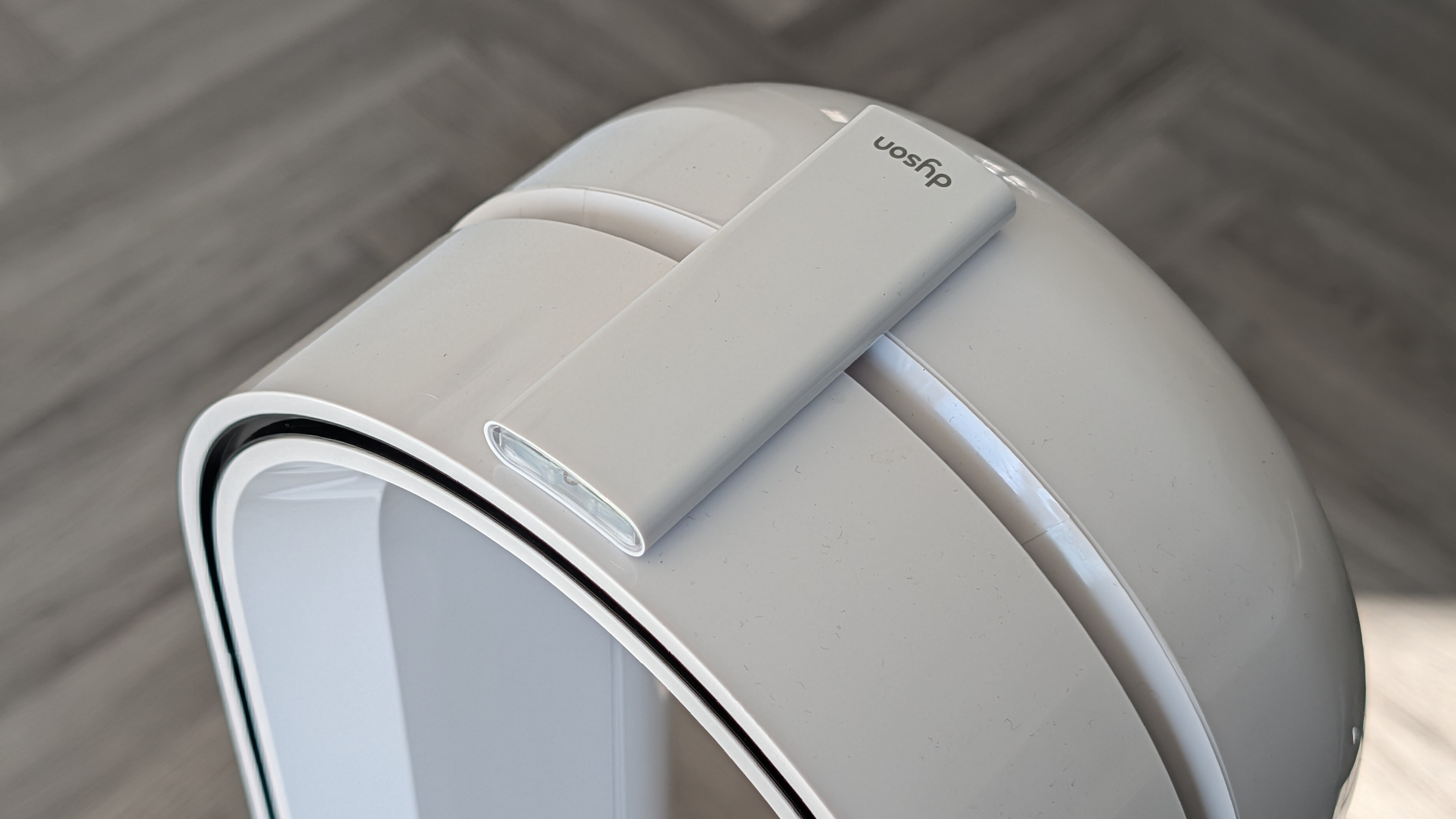 A closeup of the Dyson Find+Follow Purifier Cool's remote magnetically connected to the fan.