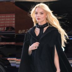 Anya Taylor Joy with her blonde hair pulled into an updo hairstyle. She's wearing a strapless white dress and a necklace.