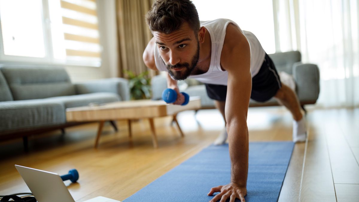 man performing a dumbbell push up at home