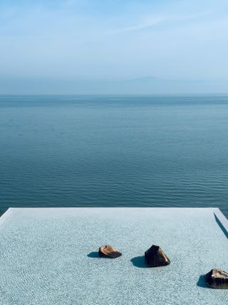 bridge house swimming pool with rippling blue waters and infinity edge towards the sea