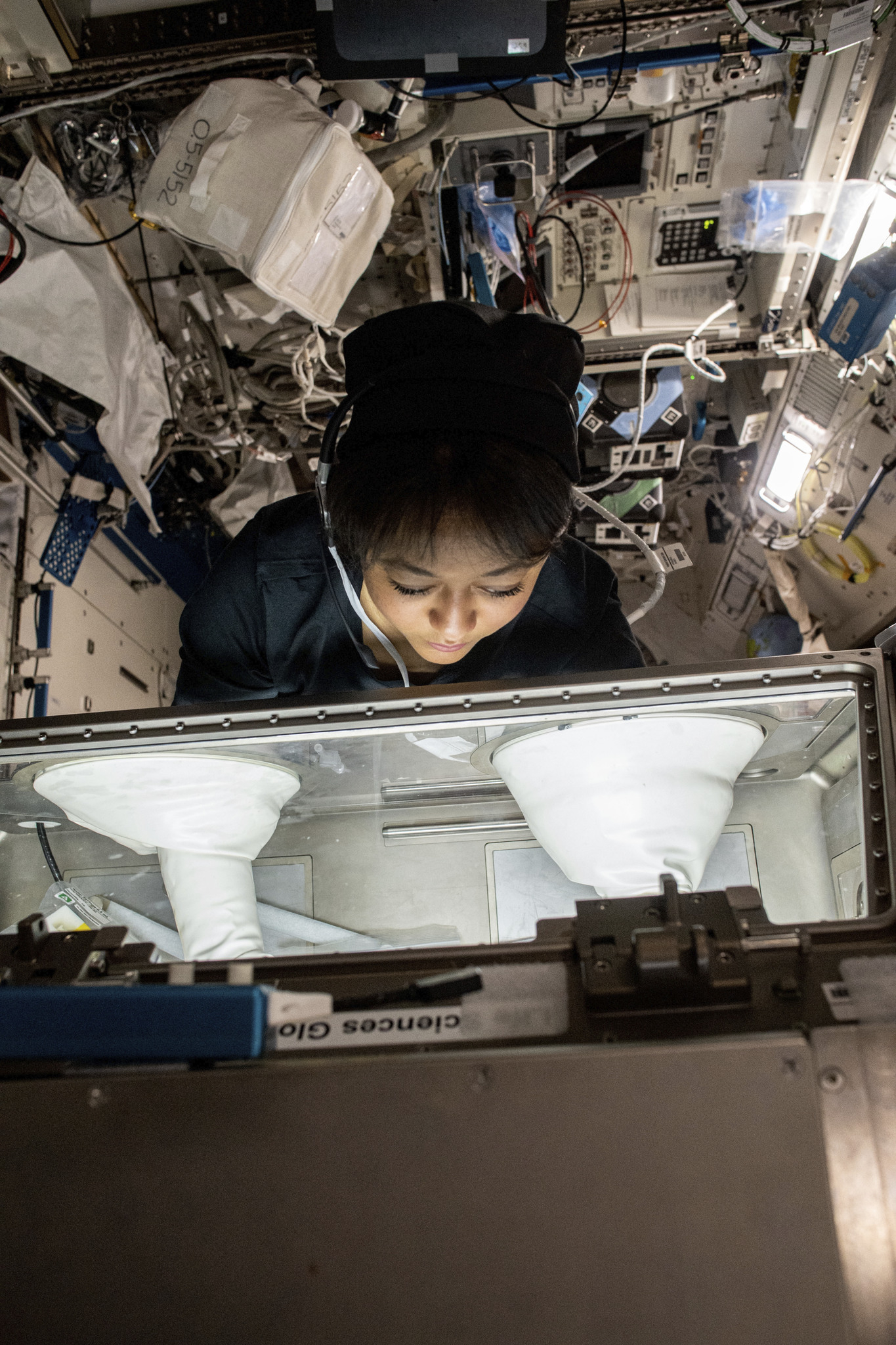 Saudi Space Commission astronaut Rayyanah Barnawi, the first Saudi woman in space, works at a glove box on the international Space Station during her Ax-2 mission.