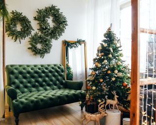 a green and white living room with christmas decor including rustic wreaths and gold decor