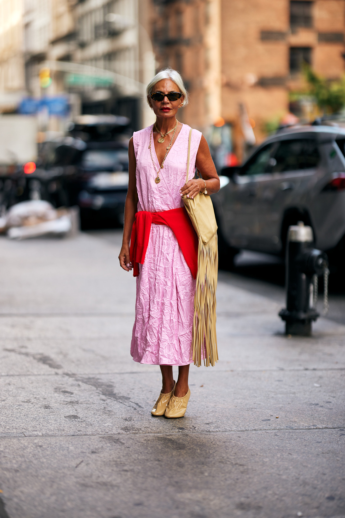 woman wearing a pink dress and a red sweater