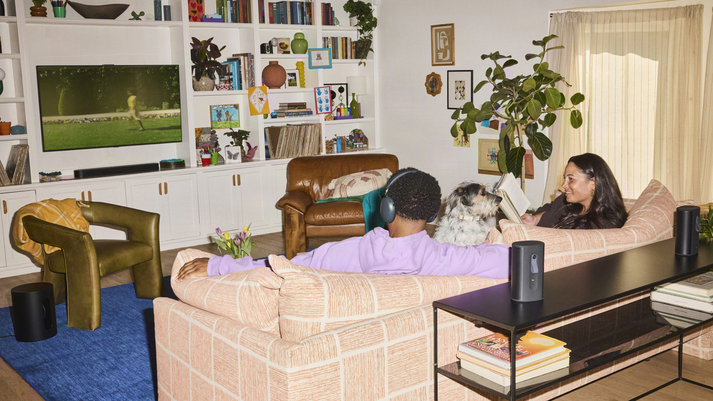 Two people in a living room with the Sonos Beam Ultra in the background