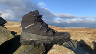 The Vivobarefoot Tracker AT hiking boot sitting on a stone wall