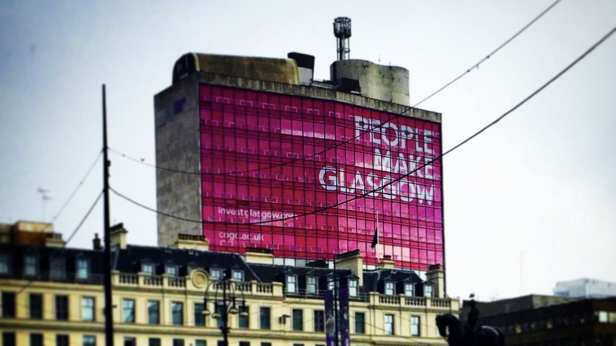 A view of a building in Glasgow city centre with a large banner on the side with the words &#039;People Make Glasgow&#039;