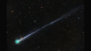 在黑色天空的襯托下,星域左下角出現了一顆亮綠色的彗星。它有一條長尾巴,一直延伸到屏幕的右上角。