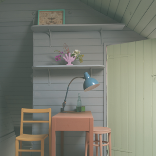 A green painted loft space with yellow chair by desk