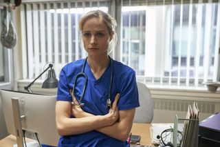 Niamh Algar in blue scrubs and stethoscope as Dr Lucinda Edwards in Malpractice.