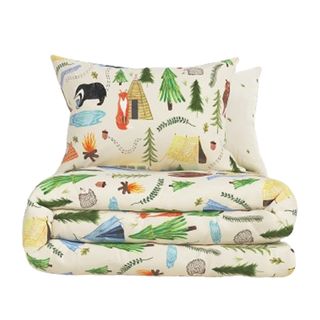 A kids bedding set with illustrated trees and animals on