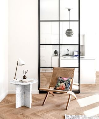 A minimalist nook with a white side table and brown wooden chair