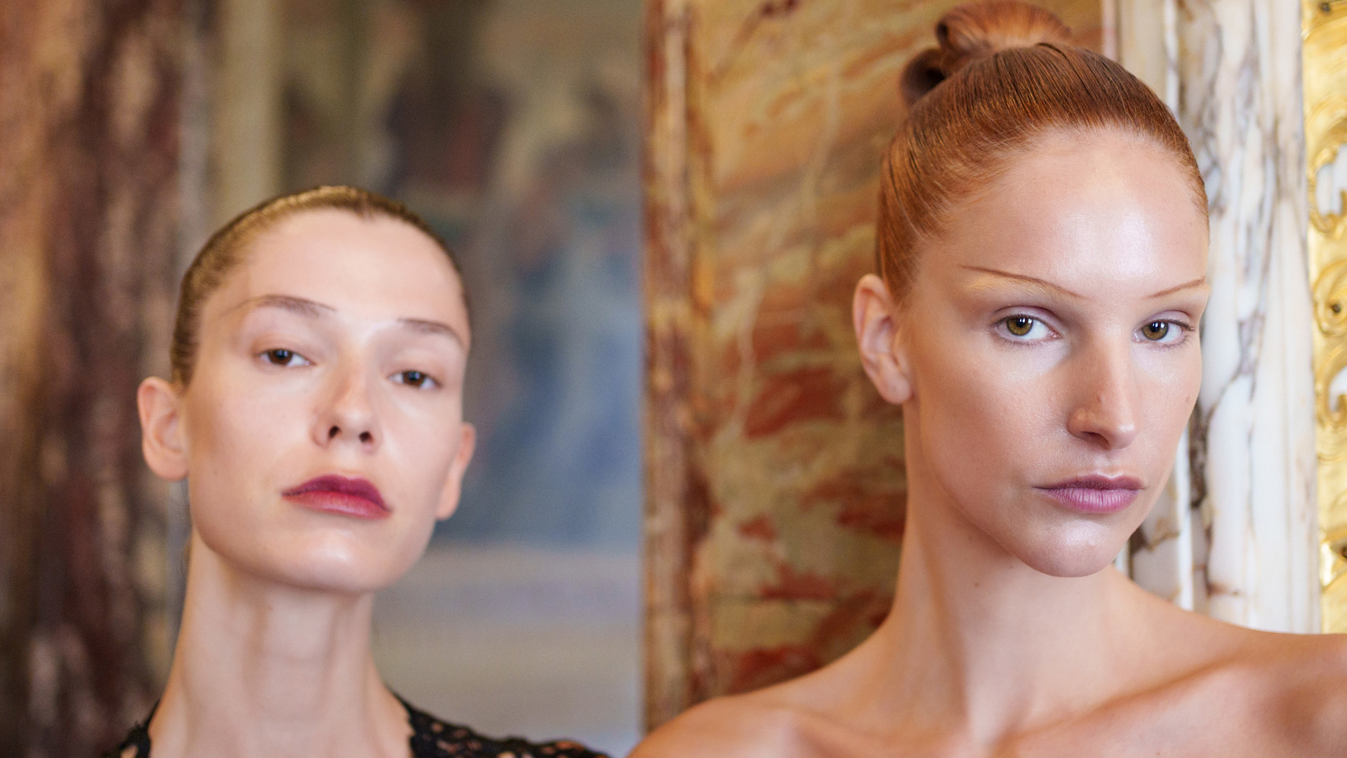 2 model with slicked buns posing for the camera.