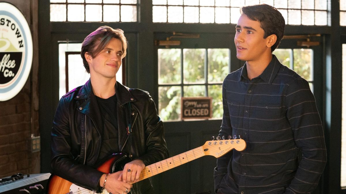 Benji holding a guitar and Victor smiling.