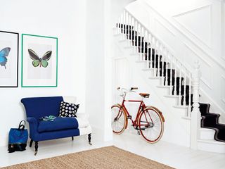 a modern hallway with an armchair and bike, painted in Dulux Satinwood White Cotton, the best white paint for wood