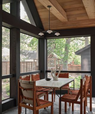 sunroom dining room with vintage furniture and a wooden paneled ceiling