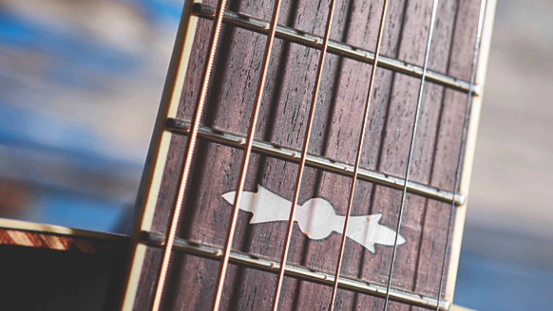 Close up of the inlay on the fingerboard of an acoustic guitar
