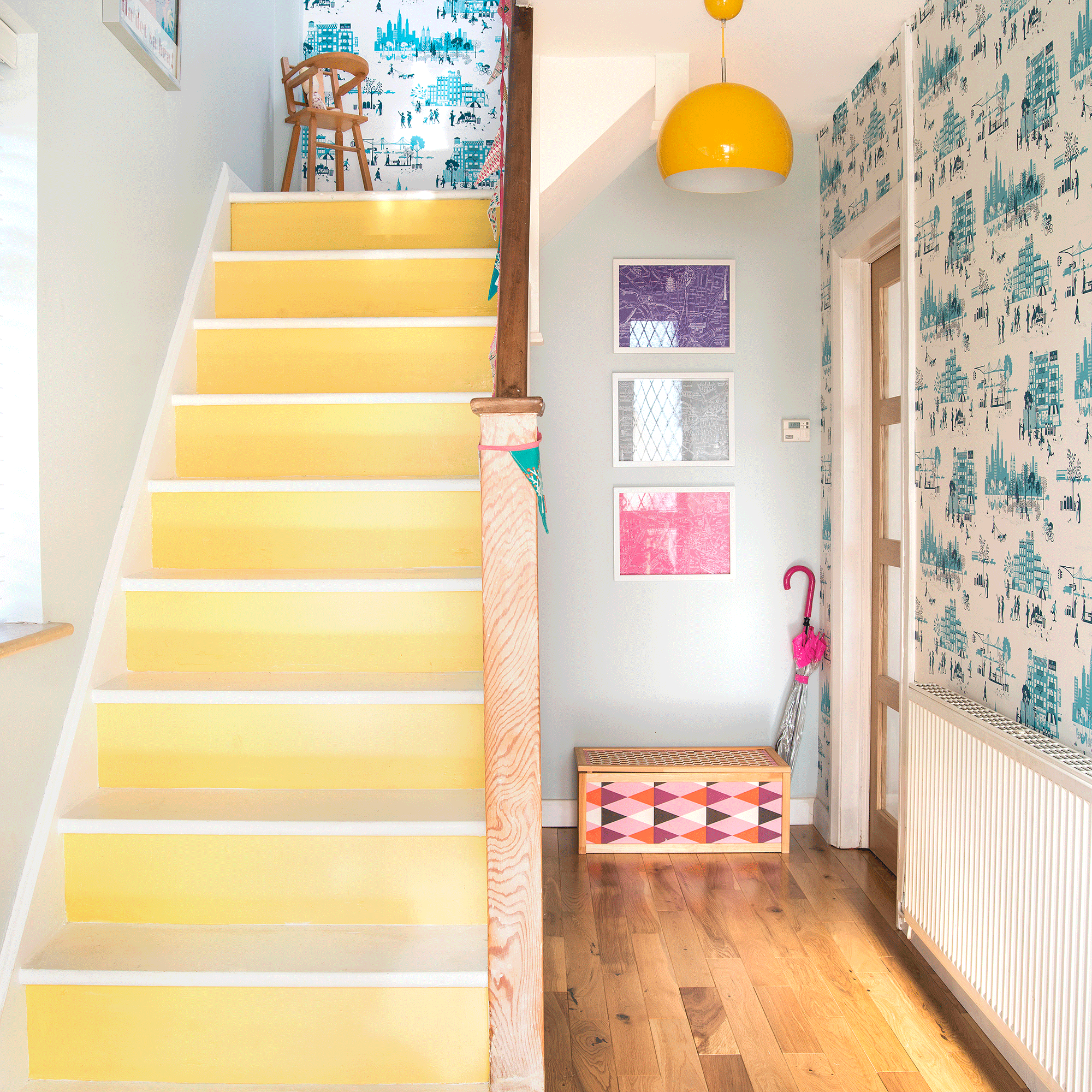 Yellow staircase with wallpapered hall