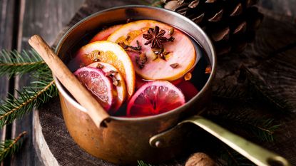 A wilver pan willed with apples, water, and cinnamon