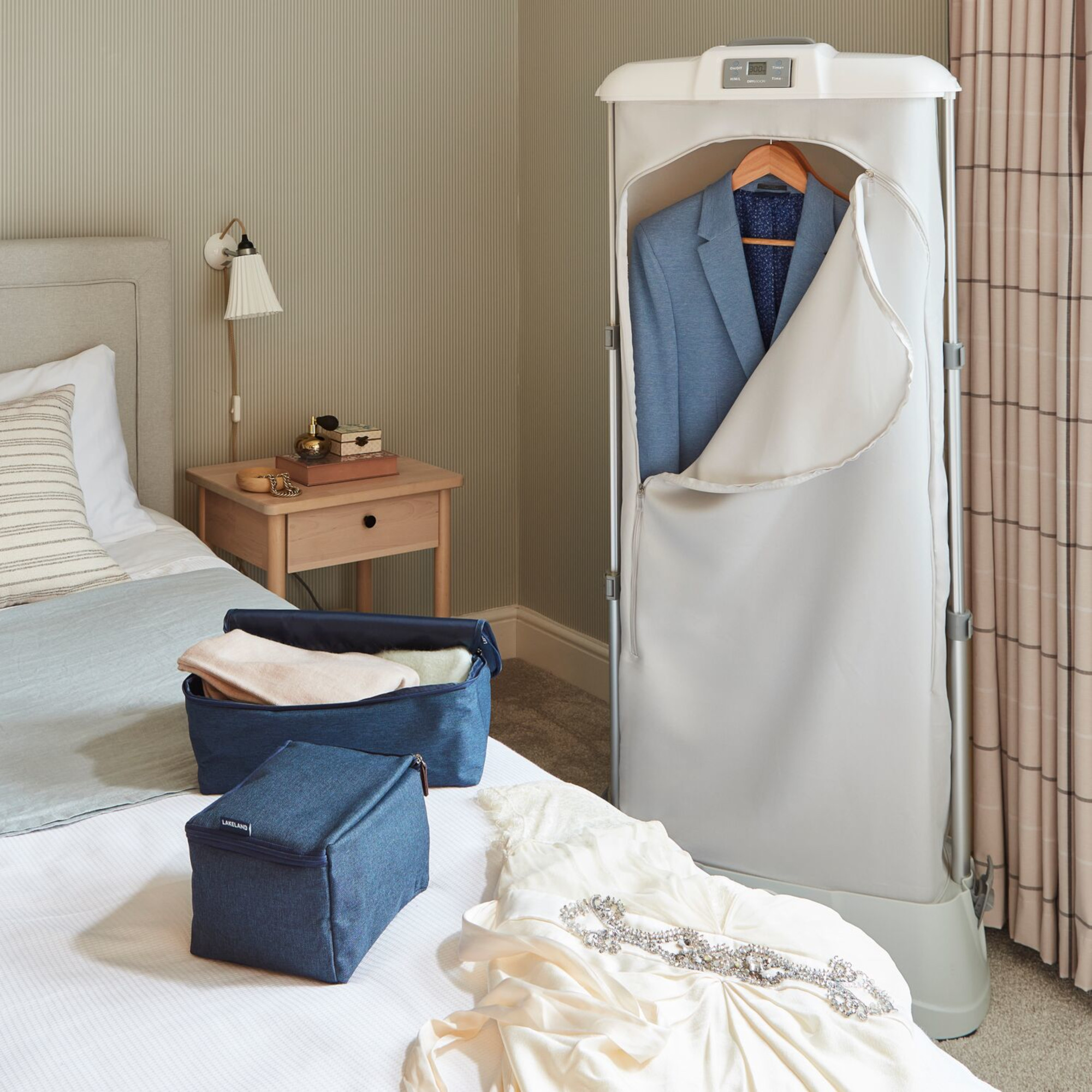 lakeland drysoon foldable heated airer in a bedroom with a suit and wedding dress
