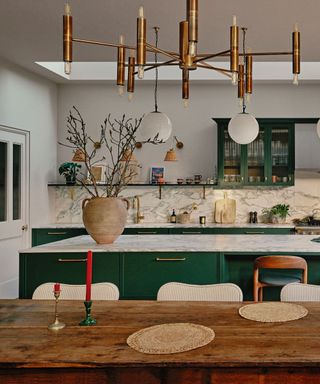 sitting room with dining area with grey marble and green cabinets