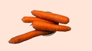 Seven large carrots sitting in a bowl to represent 200 calories worth of vegetables