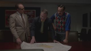 Men looking over a map in How Disney Built America