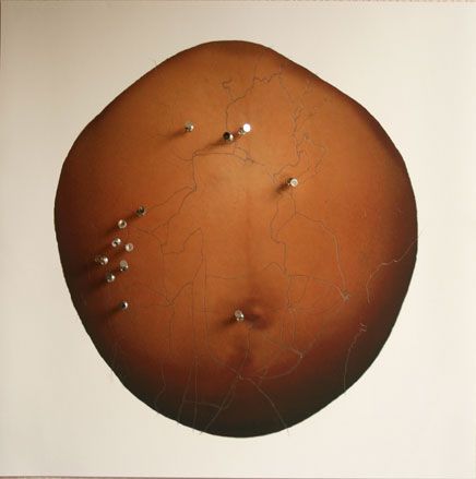 A pregnant belly with cities drawn over it and push pins stuck into it