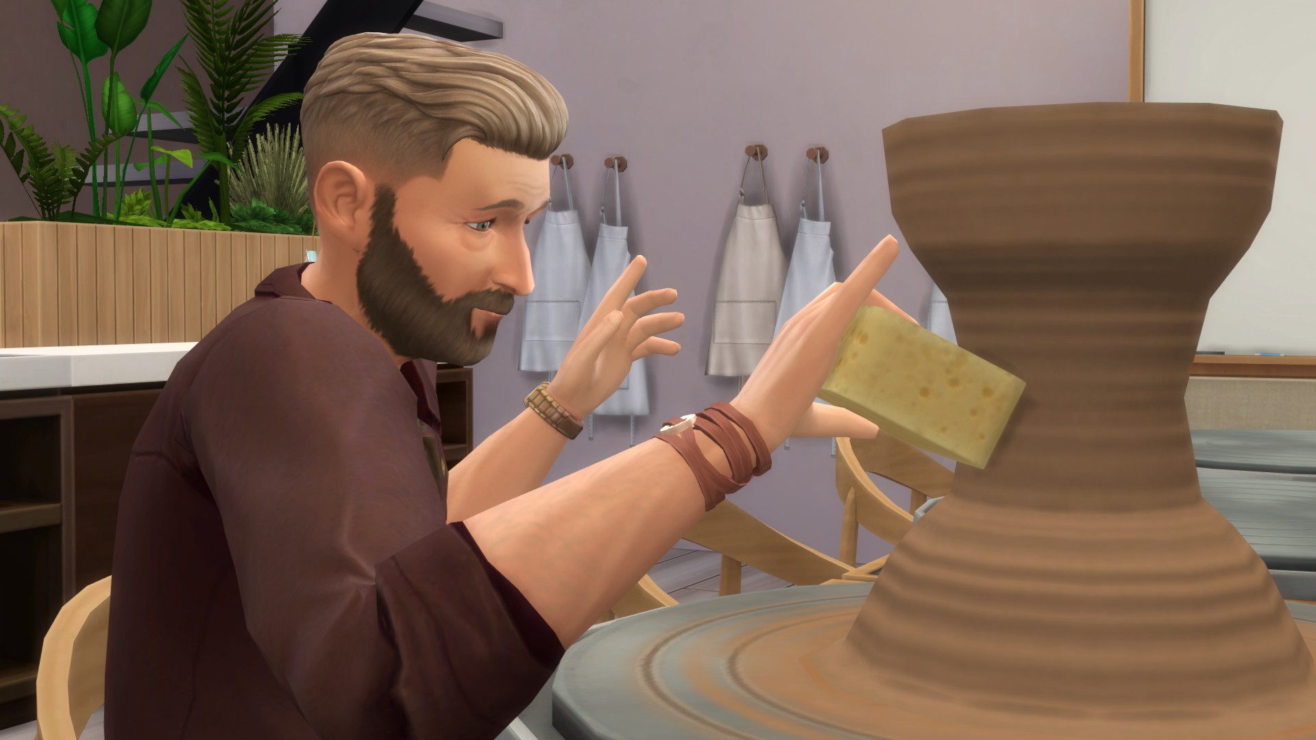 The Sims 4 Businesses &amp;amp; Hobbies - A sim brushes a pot with a sponge on a pottery wheel