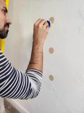 Creating a DIY Polka dot accent wall with sponge and gold paint