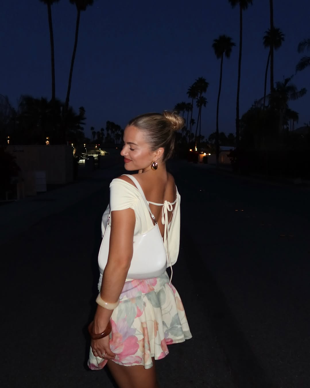 woman wearing floral mini skirt and white top