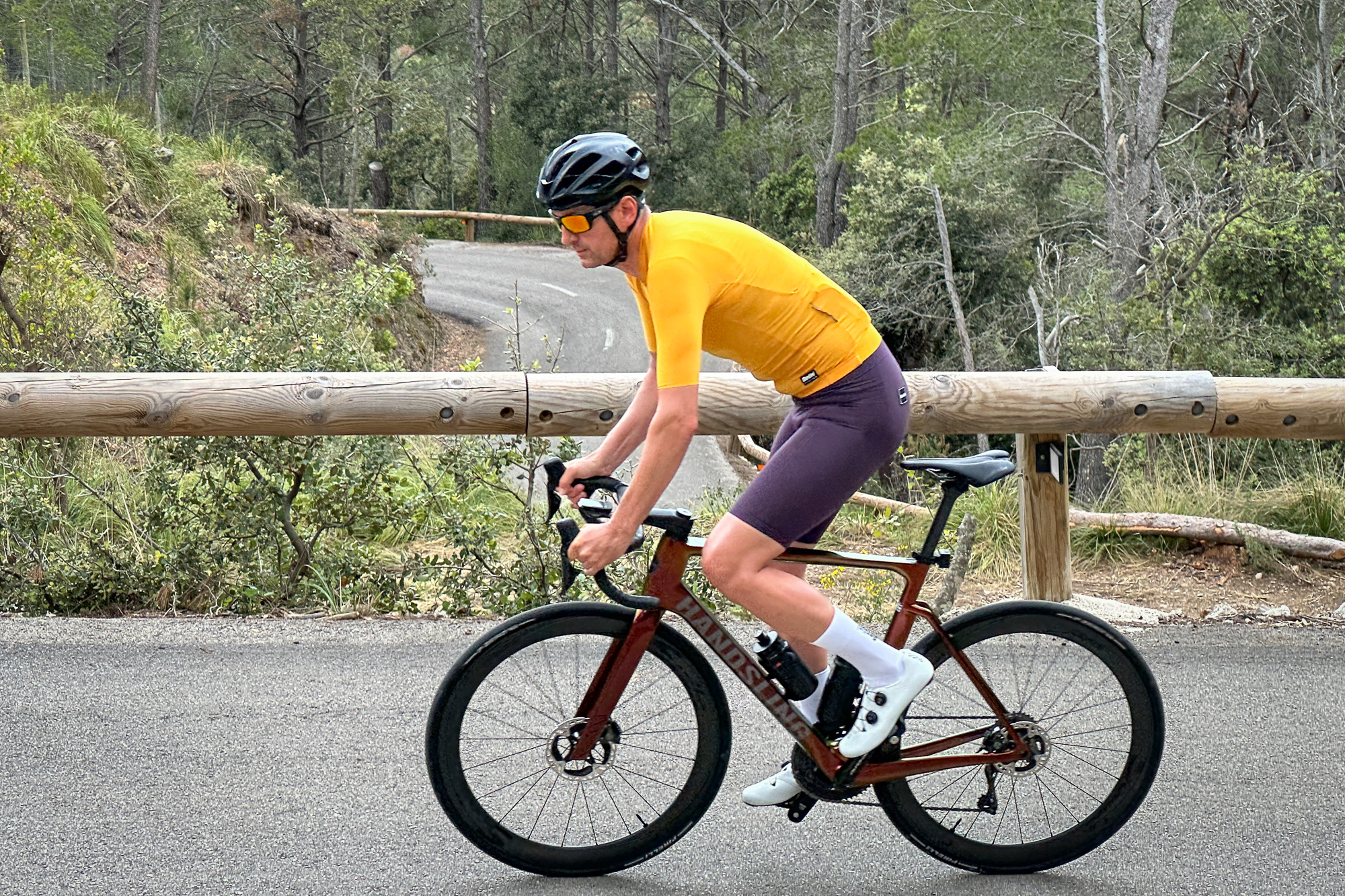 Man in a yellow jersey riding an A1R0evoS road bike up a hill in Mallorca