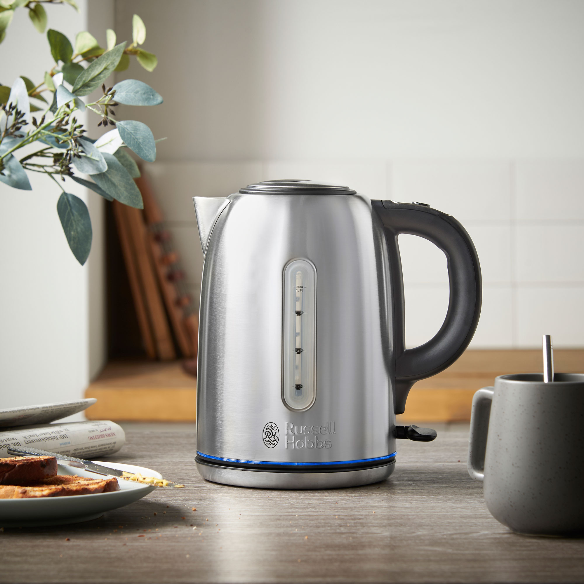 stainless steel kettle with black handle in kitchen