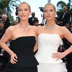 Amelia and Eliza Spencer wearing the same dress in black and white on the Cannes red carpet