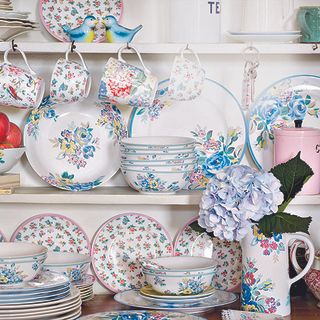 printed dishes on shelves and flower in vase