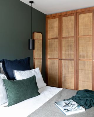 A bedroom with a tall storage cupboard