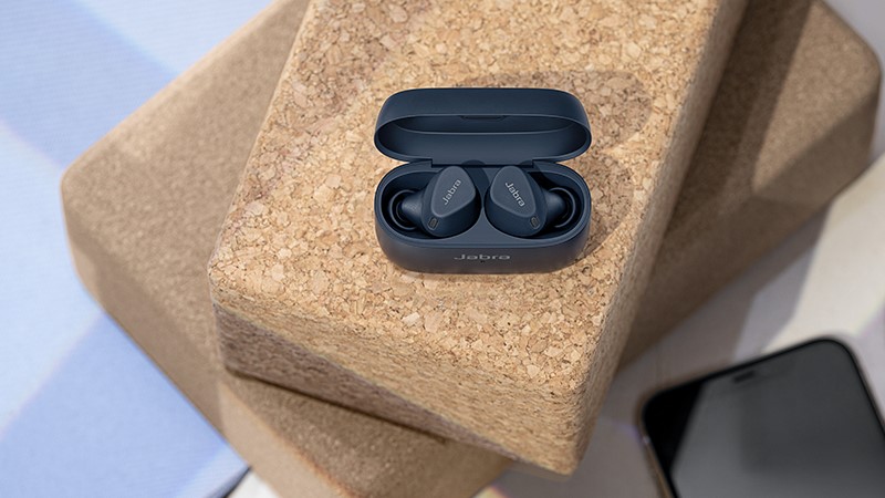 Jabra Elite 4 earbuds on wood surface